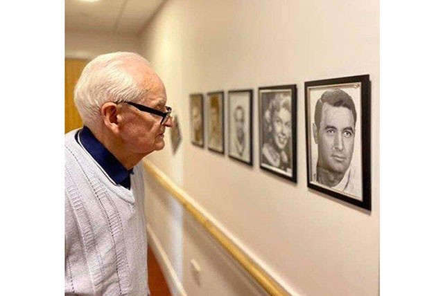 A resident looking at framed photographs ofRock Hudson and Dorris Day